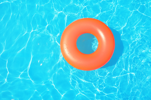 Inflatable ring floating in swimming pool on sunny day, top view - Photo, Image