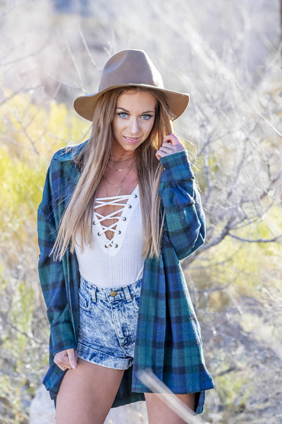 A beautiful blonde model posing in an outdoor desert environment - Zdjęcie, obraz