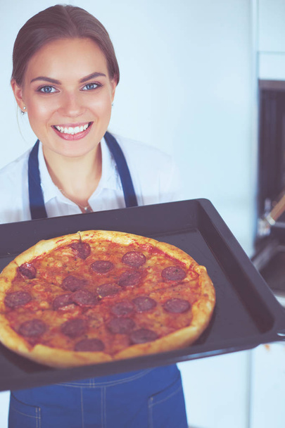 Happy young woman cooking pizza at home - Фото, зображення