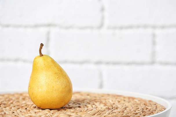 Ripe pear on table near brick wall. Space for text - Foto, Imagen
