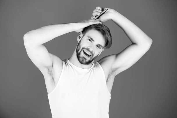 Happy man combing healthy hair with brush - Photo, image