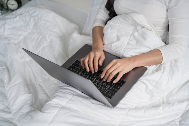 closed-up woman using a laptop computer on bed - Foto, Imagem