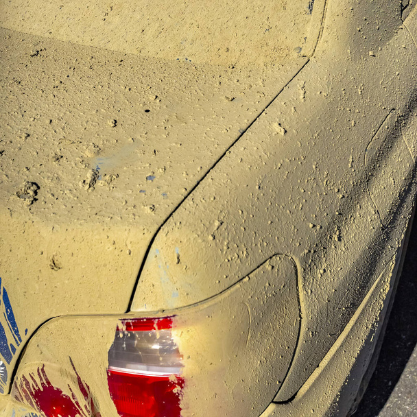 Μπλε αυτοκίνητο με κόκκινο φανάρι πίσω καλύπτονται σε λάσπη - Φωτογραφία, εικόνα