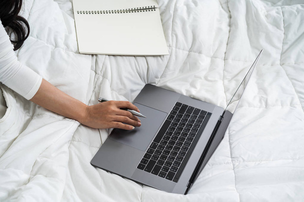 zárt-up nő dolgozik a laptop egy ágy - Fotó, kép