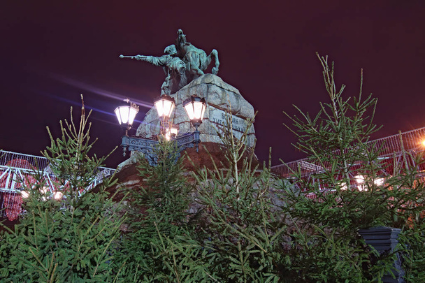 Mercado de Navidad en la plaza Sophia en Kiev, Ucrania. El monumento al famoso hetman ucraniano Bogdan Khmelnitsky está decorado con abetos jóvenes. Vista temprano por la mañana
. - Foto, imagen