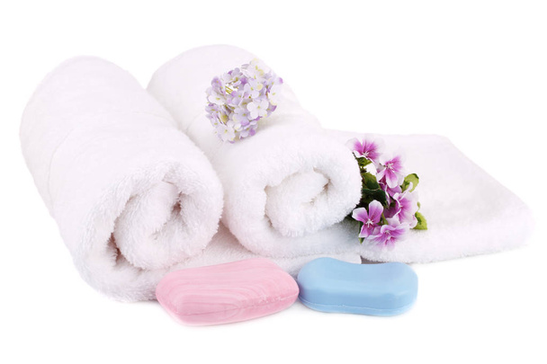Asciugamani bianchi laminati con saponi e fiori isolati su sfondo bianco
. - Foto, immagini