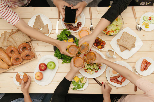 Kolacji z przyjaciółmi. Widok z góry grupy ludzi obiad razem siedząc przy stole drewniane - Zdjęcie, obraz