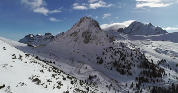 Προς τα εμπρός κεραία πάνω από το χιονισμένο κοιλάδα με ξύλα δάσος και στροφή φουρκέτα δρόμο στο πέρασμα του Pordoi. Ηλιόλουστη ημέρα με συννεφιά. Χειμώνα πτήση drone establisher.4k εξωτερική φύση βουνά Δολομίτες ιταλικές Άλπεις. - Πλάνα, βίντεο