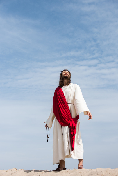 Jeesus kaapu, punainen vyö ja kruunu piikkejä tilalla rukous ja katselee ylös autiomaassa
 - Valokuva, kuva