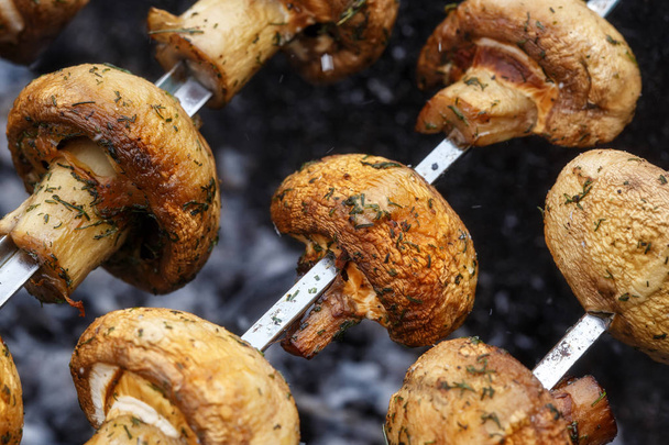 Barbecue skewers with delicious grilled champignon mushroom kebab in a brazier - 写真・画像