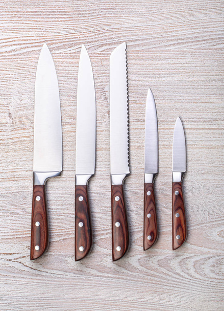 cinq couteaux de cuisine sur planche en bois
 - Photo, image