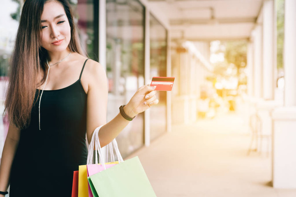 Красивая азиатка держит кредитку в торговом центре
. - Фото, изображение