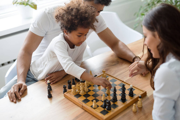 Happy family playing chess together at their home - Photo, Image
