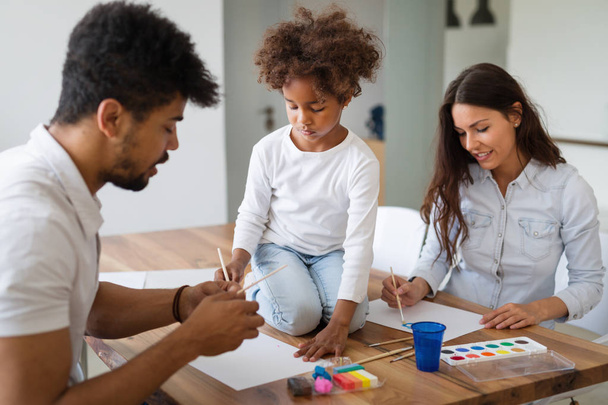 Mother and father drawing together with their child at home - Foto, Imagen