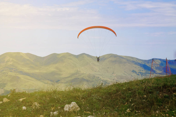 Siklórepülés, az ejtőernyőzés, a hegyek felett repülő hegység. ejtőernyős extrém sport - Fotó, kép