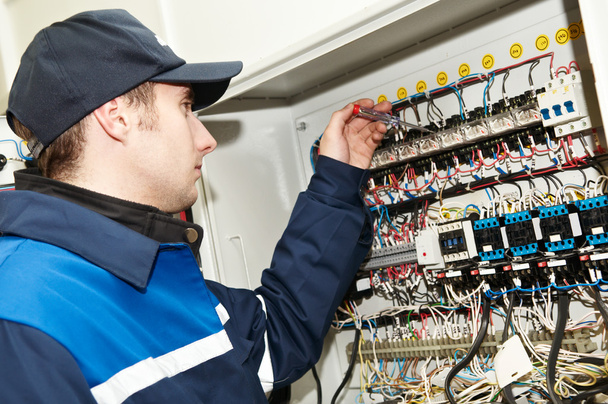Electrician at voltage adjusting work - Foto, Imagen
