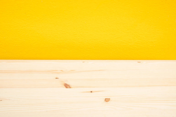escritorio de madera vacía y fondo amarillo pared. Espacio en blanco para texto e imágenes
. - Foto, Imagen