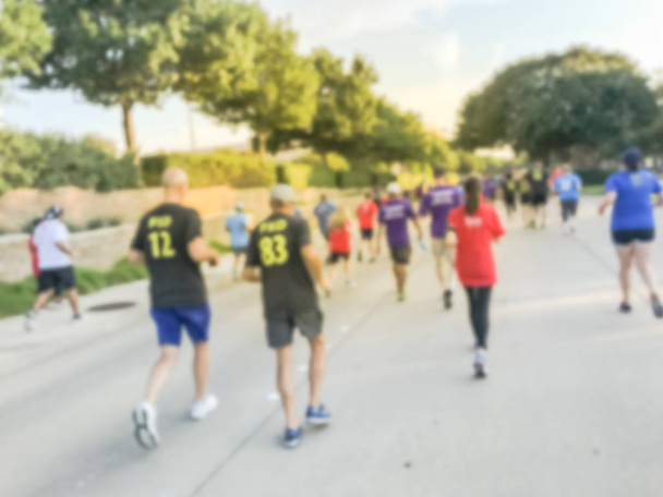 Motion blurred group runners of all abilities at 5K Corporate Challenge race in Richardson, Texas, US. Fitness and healthy lifestyle concept. Athletes running on the roads. Urban sport event abstract - Photo, Image