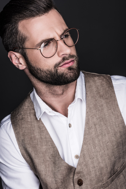 portrait of handsome bearded man posing in eyeglasses, isolated on grey - Foto, imagen