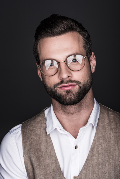 portret przystojny mężczyzna pewność w okularach i stylowe kamizelki, na szarym tle - Zdjęcie, obraz