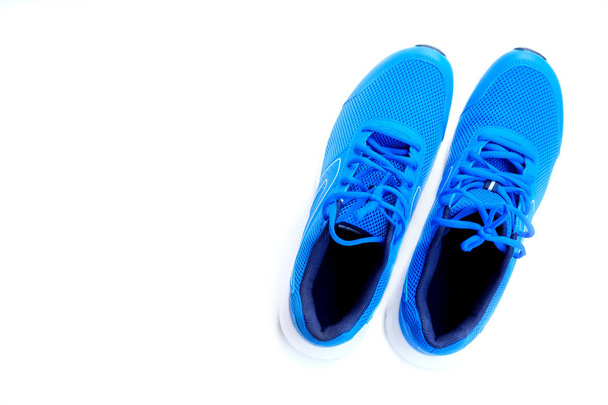 Концепция запущена. Концепция любовного пробега. Синие кроссовки для мужчин на белом фоне. Вид сверху
 - Фото, изображение