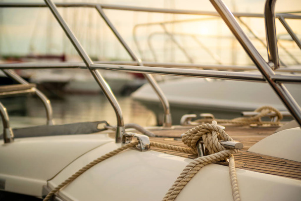 White mooring rope tied around steel anchor on boat - Φωτογραφία, εικόνα