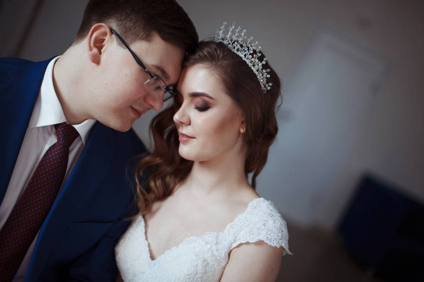 Şık damat gözlük ve mavi bir takım elbise ve bir gelin düğün dekorasyonu ile saç stili giyiyor. Kadar evli clouse - Fotoğraf, Görsel