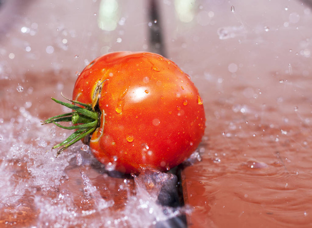 Tomato on a wooden surface illustrating fresh food and harvest season - Fotografie, Obrázek