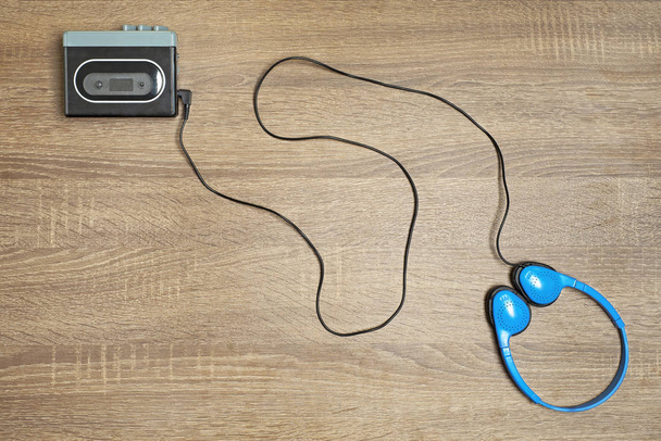 Retro walkman preto e fones de ouvido azuis em fundo de madeira
. - Foto, Imagem