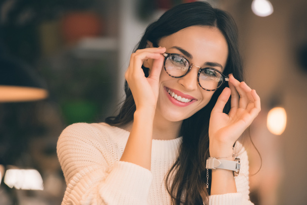 portrait of happy attractive woman taking off eyeglasses in cafe  - Photo, Image