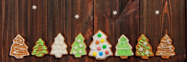 Vánoční perníčky ve tvaru vánočních stromků na hnědý dřevěný stůl. Kopírovat prostor - Fotografie, Obrázek