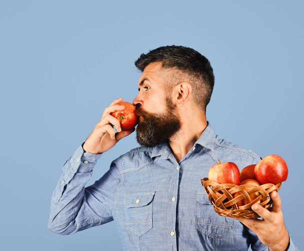 Gardening and fall crops. Farmer with busy face kisses apple - Valokuva, kuva