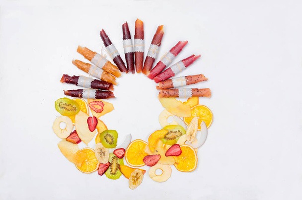varietty of dry fruit chips and fruit leather rolls on white background with an empty space for text,. Detox concept. Healthy food, Fruits amazing candy. - Foto, afbeelding