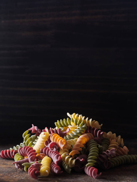 Värikäs kuivattu fusilli pasta puulaudalla
 - Valokuva, kuva