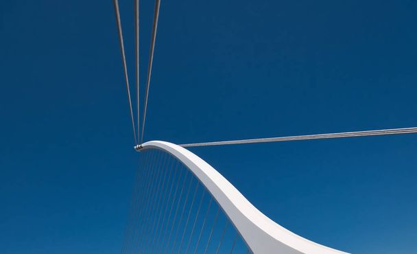 Valkoinen silta pilari venytetty teräs köydet ja sininen taivas taustalla
 - Valokuva, kuva