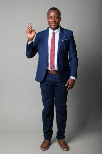 Bote de cuerpo completo de joven empresario africano feliz con traje azul
 - Foto, imagen