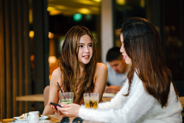 молоді і привабливі жінки обговорюють в кафе
. - Фото, зображення