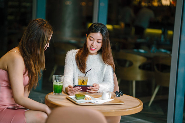молоді і привабливі жінки обговорюють в кафе
. - Фото, зображення