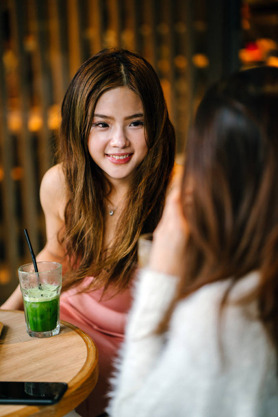 young and attractive  women  having a discussion in a cafe. - Foto, afbeelding