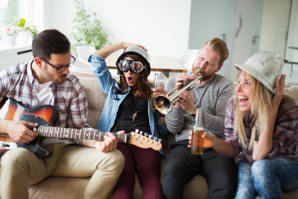 Ryhmä ystäviä hauskaa ja juhlimista talossa ja musiikin soittaminen
 - Valokuva, kuva