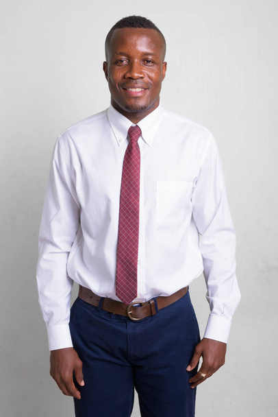 Young happy African businessman against white background - Φωτογραφία, εικόνα