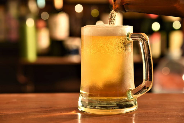 bira şişesinden pub masada cam içine dökme - Fotoğraf, Görsel