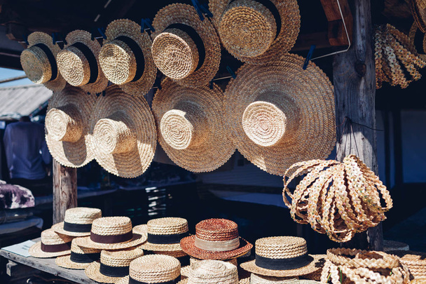 Zobrazit s vintage slaměné klobouky a doplňky v outdoor shopu. Prodej stylové letní klobouky zavěšené na showcase - Fotografie, Obrázek