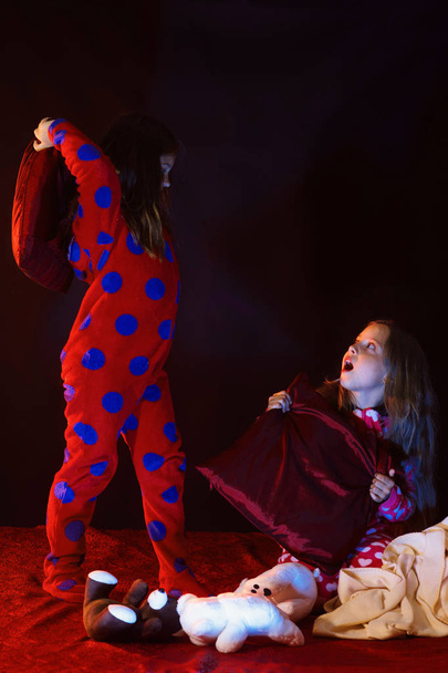 Kids in pajamas have pilllow fight, copy space - Zdjęcie, obraz