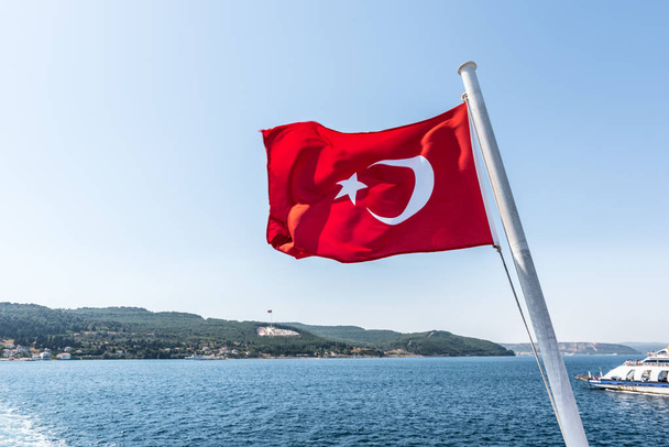 Török zászló és Dur Yolcu emlékműve, háttérben a Kilitbahir járásban, Canakkale, Törökország - Fotó, kép