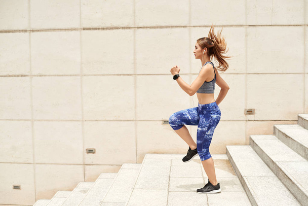Sportive žena běží na schodech  - Fotografie, Obrázek