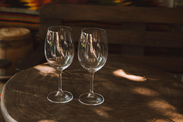 Nahaufnahme von Weingläsern auf rustikalem Holztisch - Foto, Bild