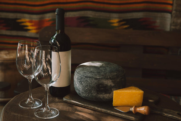 close-up shot of cheese and wine on rustic wooden table - Photo, Image