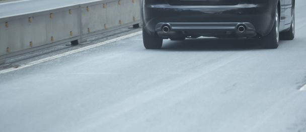 Задняя и выхлопная трубы автомобиля на шоссе
 - Фото, изображение