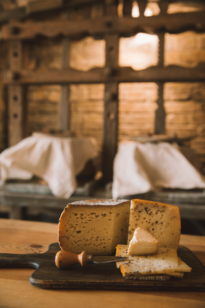 νόστιμο τυρί σε φέτες με μαχαίρι σε ξύλο κοπής - Φωτογραφία, εικόνα